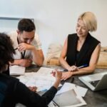 Business and technology team planning roles around a meeting table